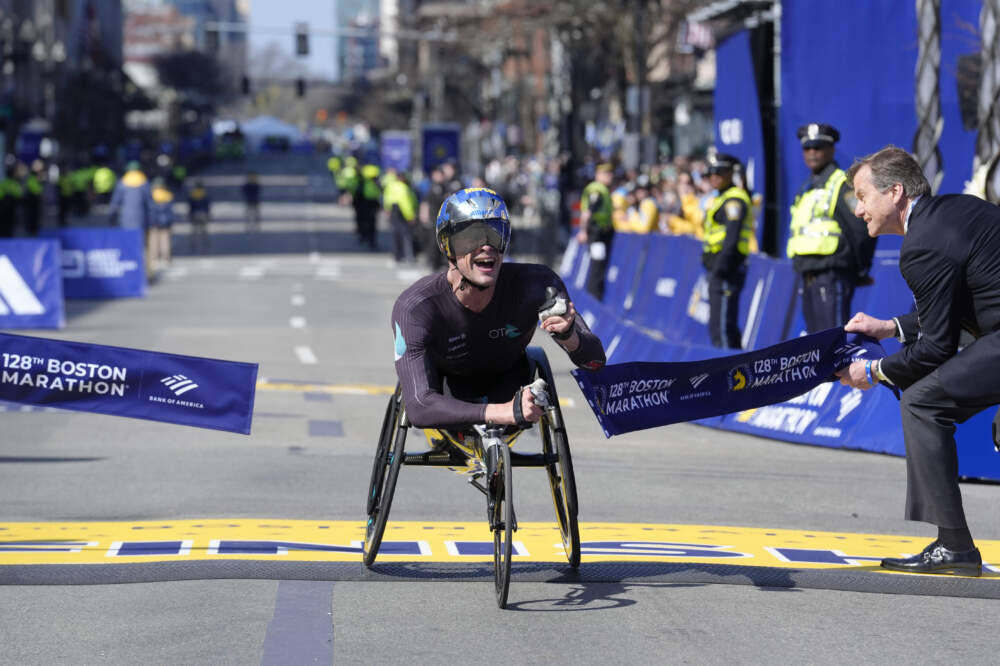 Marcel Hug, da Suíça, quebra a fita para vencer a divisão masculina em cadeiras de rodas da Maratona de Boston em 15 de abril de 2024. (Steven Senne/AP)