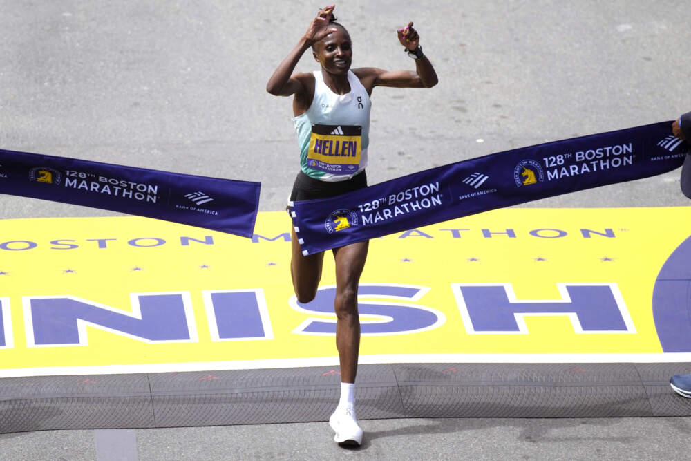 A queniana Hellen Obiri levanta os braços ao cruzar a linha de chegada para vencer a divisão feminina da Maratona de Boston. (Charles Krupa/AP)